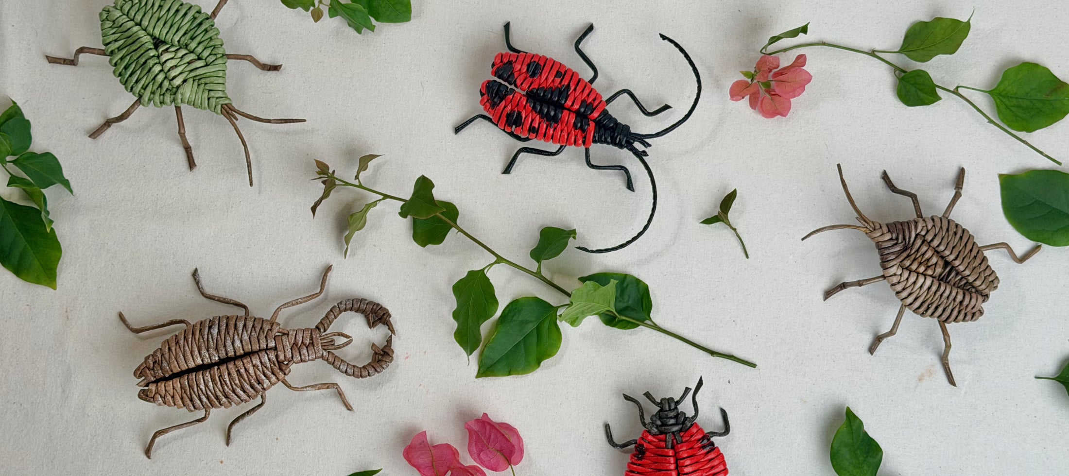 Paper vine woven bugs by Weevyn on a neutral background with green leaves