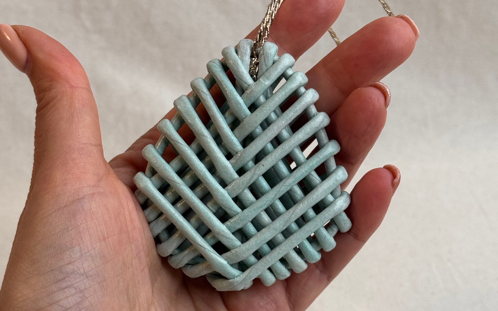 Woven decorative paper vine egg in hand