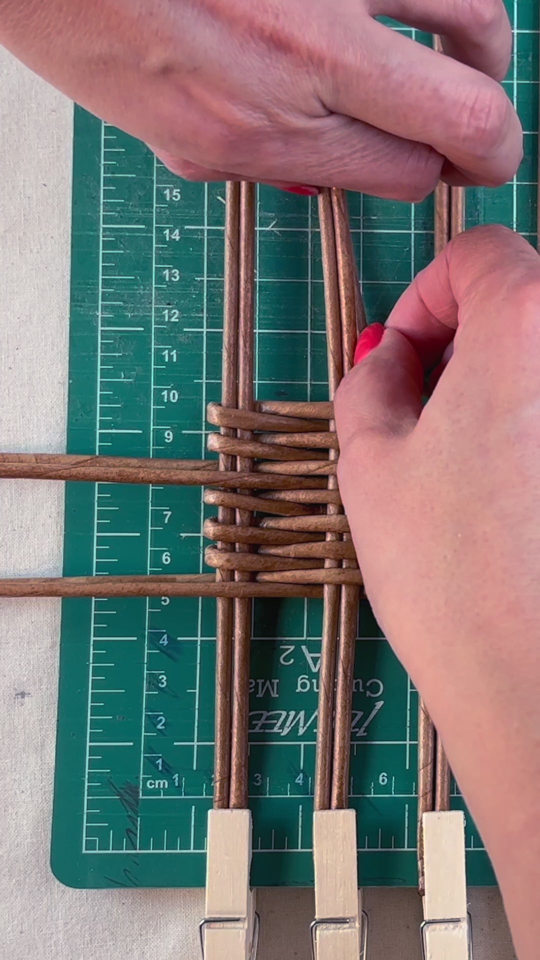 Load video: A woman weaving a tea box with paper vine