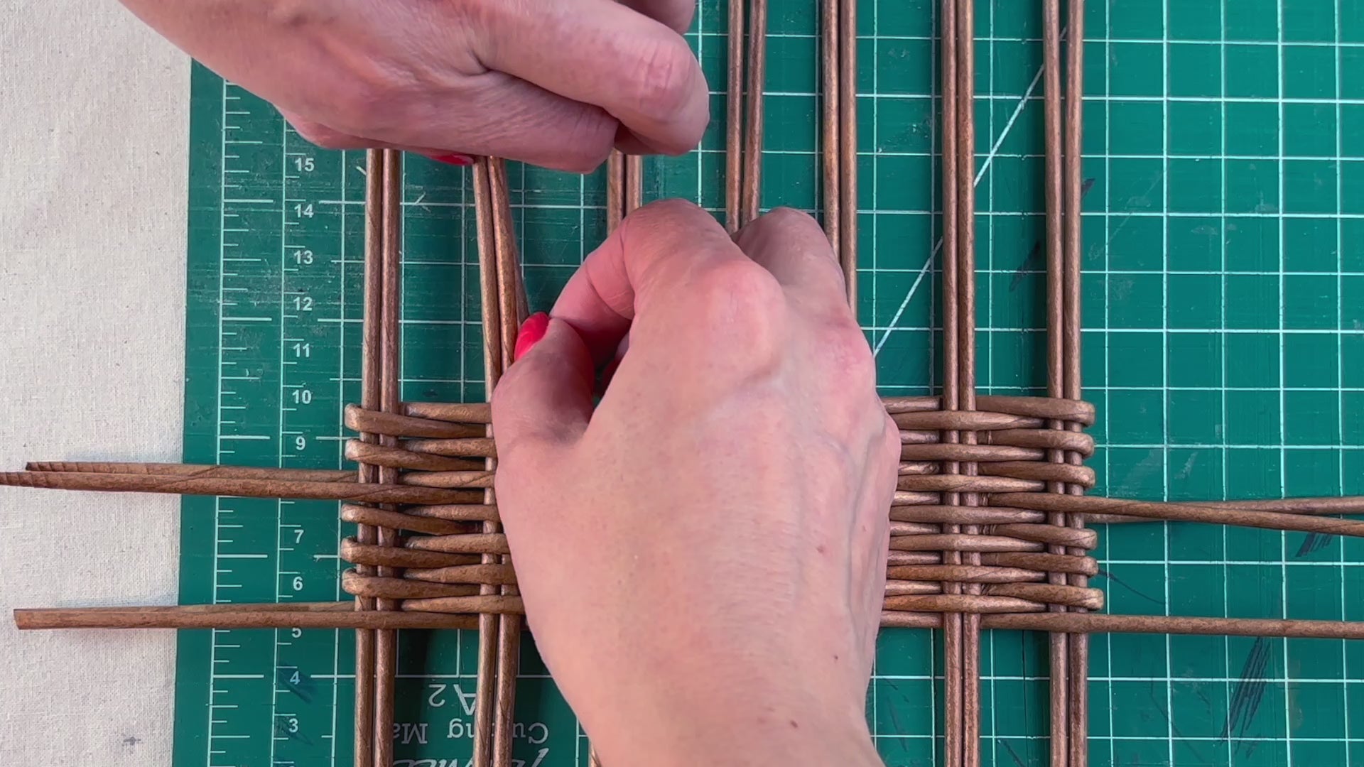 Load video: A woman weaving a tea box with paper vine